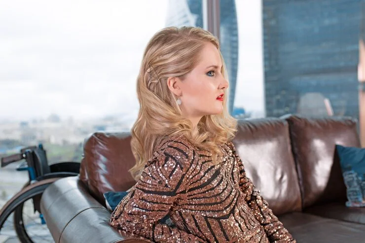 beautiful young blonde girl fashionable dress with disability posing leather sofa against surface wheelchair 124865 8186